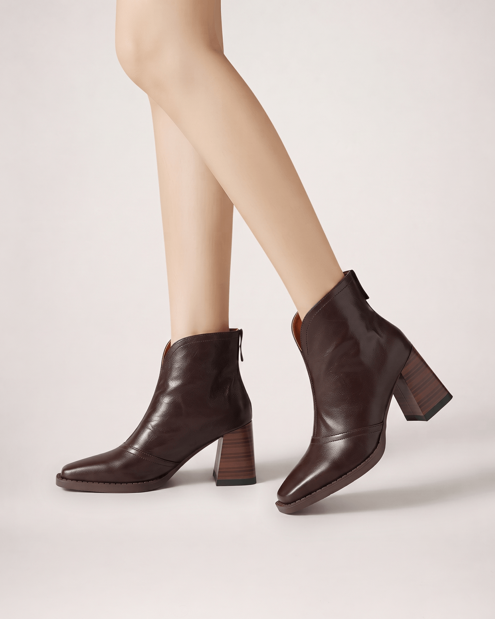 Dark Brown women’s boots worn in a crossed studio pose