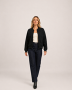Women’s black zip up cardigan full body walking view